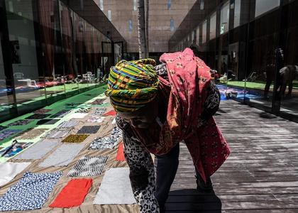 Fabrics of Memory – several scarves and pieces of fabric are laid out on the ground.
