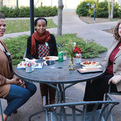 Three members of the ICGC team chat at an outdoor table